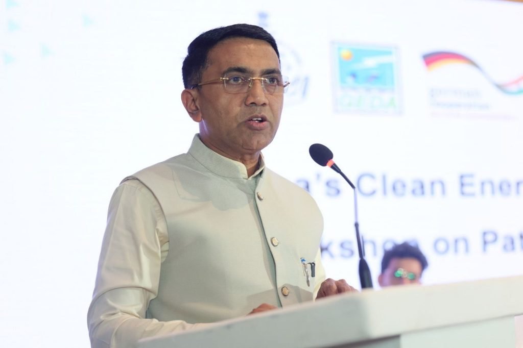 Goa Chief Minister Dr. Pramod Sawant standing on stage with government officials and German GIZ delegates holding up clean energy policy booklets at a workshop in Miramar, Panaji.
