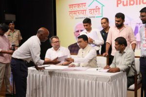 Goa Chief Minister Dr. Pramod Sawant seated at a desk accepting a grievance document from a citizen during the Sarkar Tumchya Dari event in Curchorem.